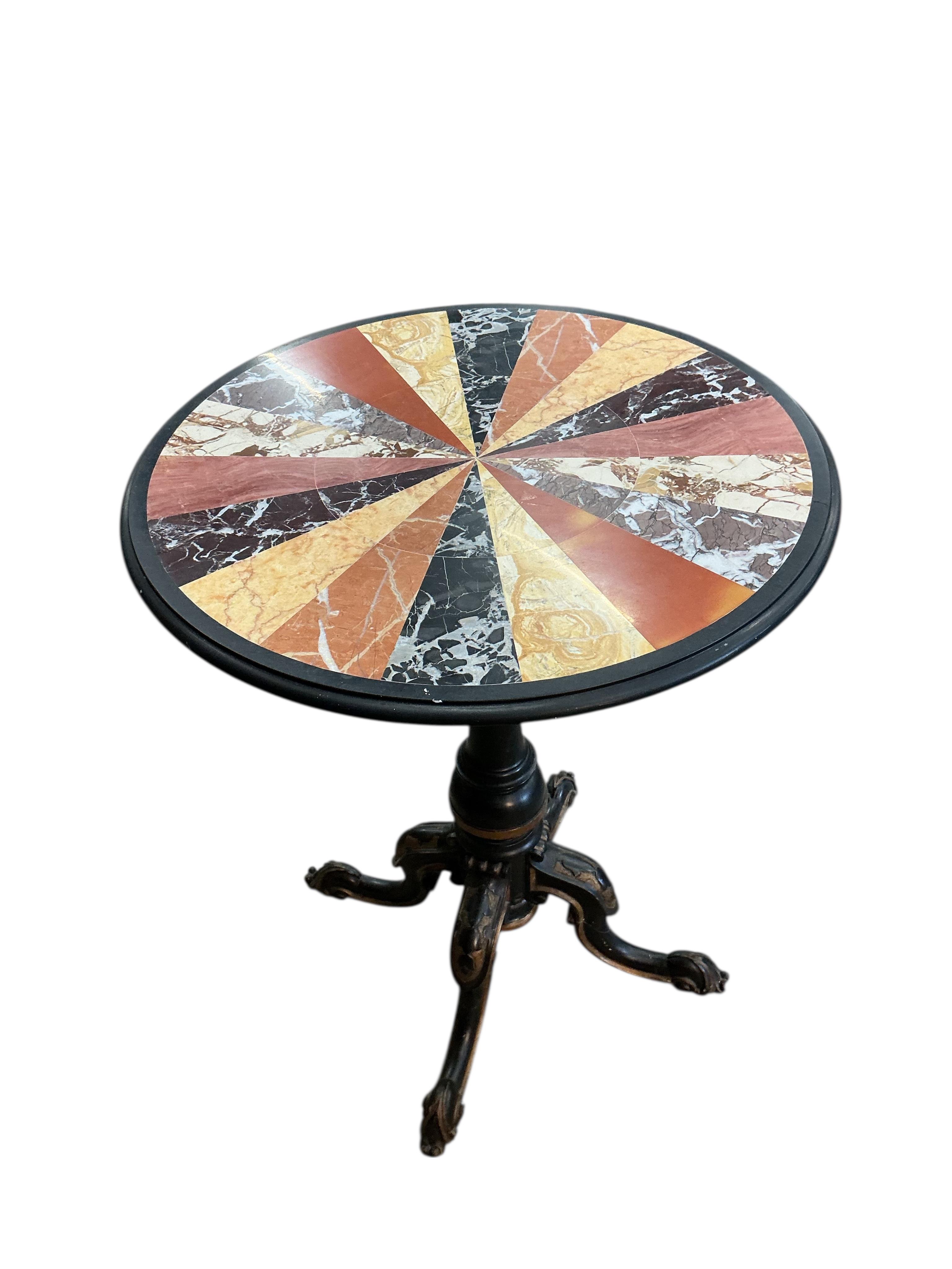 A circular specimen marble occasional table on a Victorian ebonised tripod base, diameter 53cm, height 69cm